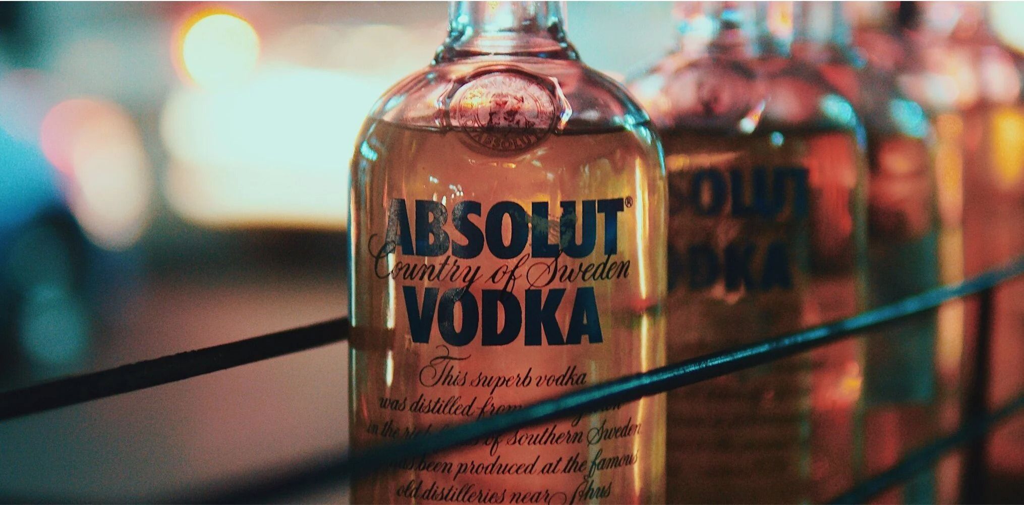 Absolut Vodka (앱솔루트 보드카) 병 여러 개가 나란히 진열된 모습 — 브랜드 라벨 타이포그래피에서 Futura 계열의 영향이 보인다